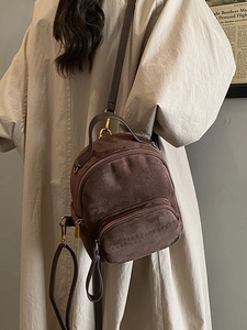 Vintage brown leopard suede backpack with gold hardware shown on a model in a trench coat