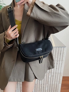 Minimalist black half-moon crossbody bag with golden double zipper and wide shoulder strap