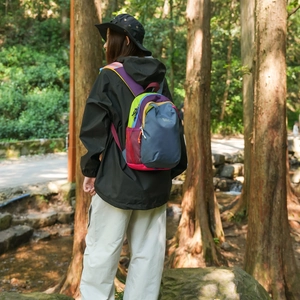 Detail of multi-color hiking backpack showing side mesh pocket and durable functional fabric