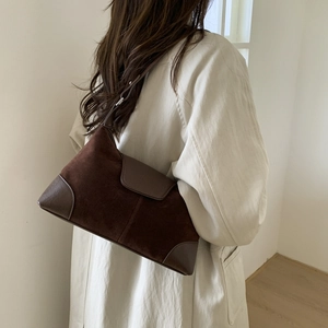 Detail of vintage faux suede hobo bag shown with a minimalist cream wool coat