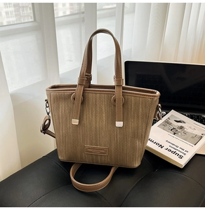 Detail of coffee woven texture tote bag with leather handles and adjustable shoulder strap