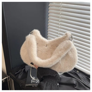 Détail de la texture pelucheuse beige et de la bandoulière en chaîne argentée du sac