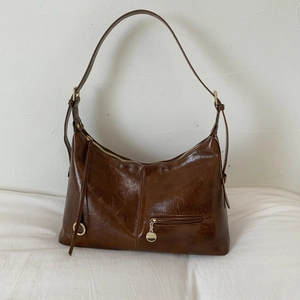 Close-up of the vintage dark brown leather hobo bag with gold hardware and褶皱纹理 details