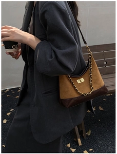 Detail of vintage rhombic pattern crossbody bag with brown suede and golden chain strap