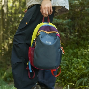 Detailed close-up of colorful patchwork hiking backpack with side mesh pocket and buckle