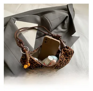 Detail view showing internal storage of leopard print crescent bag with beaded strap