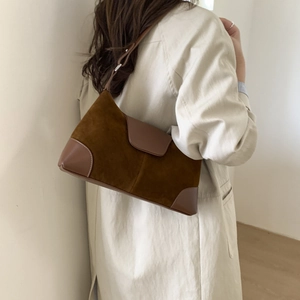 Brown suede crossbody bag with leather trim detail shown from a side view on a model