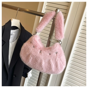 Détail du sac en fausse fourrure rose avec clous étoiles et bandoulière peluche