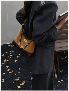 Detail of vintage quilted crossbody bag with metal chain strap and turn-lock closure