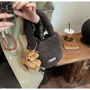 Sac seau en laine d'agneau marron avec charm d'ours et étiquette tissée en gros plan