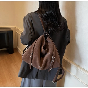 Detailed view of dark brown vintage tote bag with metal buckles on the shoulder strap