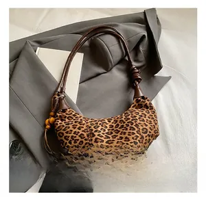 Detail of leopard print handbag with knotted leather strap and wooden bead tassels