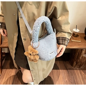 Détail du sac bandoulière en peluche bleu clair avec un ours en peluche et sangle ajustable