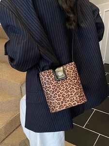 Fashionable leopard print bucket bag with black leather flap and silver buckle detail