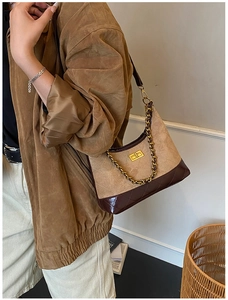 Detail shot of a brown retro crossbody bag with quilted pattern and gold chain strap