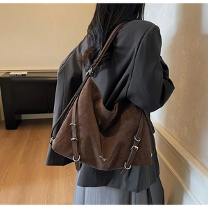 Detail view of brown large tote bag with metallic buckle straps and vintage matte texture