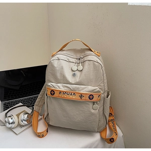 Detail of beige nylon backpack with yellow SIJCHAO webbing straps and laptop setup