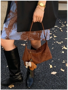 Sac croissant en daim marron avec charm ours en peluche sur fond de feuilles d'automne