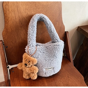 Détail du sac seau en polaire bleu clair avec un joli porte-clés ours en peluche marron