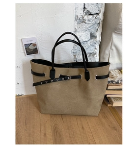 Detail of khaki suede tote bag featuring black leather strap and silver metal buckle