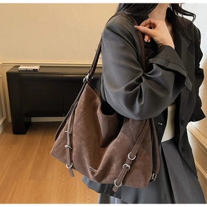 Detail view of large dark brown retro tote bag with adjustable metal buckle on shoulder strap