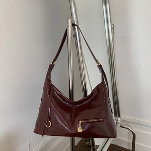 Detail view of the deep burgundy faux leather shoulder bag with vintage crinkle texture