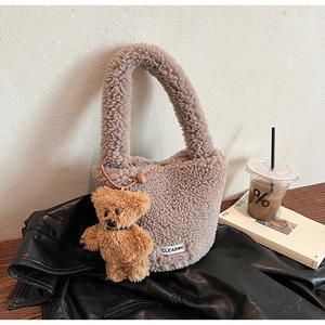 Sac seau en laine d'agneau marron avec charme d'ours et étiquette sur table en bois