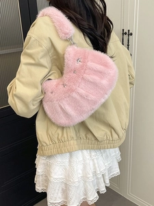 Sac croissant en peluche rose avec rivets étoiles argentés porté par un mannequin