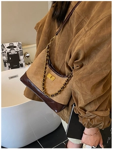Detail of vintage brown suede shoulder bag with gold chain strap and square lock