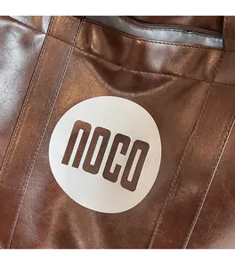 Detailed macro shot of dark brown oil-finished leather tote bag with noco brand logo