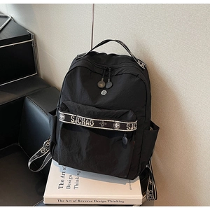 Detailed macro view of the black nylon backpack showing the SJCHAO woven strap and front zipper