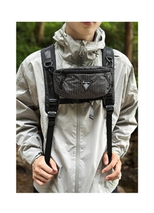 Close-up of black ripstop cross-body bag with triangle logo on outdoor jacket