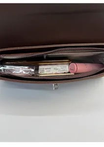 Internal view of brown leather crossbody bag showing spacious capacity and silver clasp