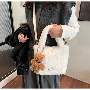 Détail du sac seau en peluche blanche avec breloque ours brun et étiquette Clear-K