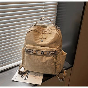 Close-up of beige nylon backpack with SJCHAO woven straps and pleated texture detail