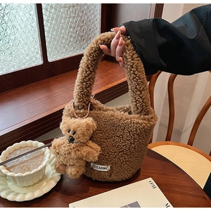 Détail du sac seau en laine d'agneau marron avec un pendentif ours en peluche