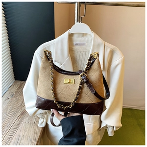 Detail of vintage quilted crossbody bag with metal chain strap and turn-lock buckle