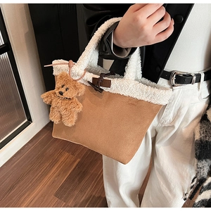 Detail of faux shearling tote bag featuring brown suede body and toggle closure detail