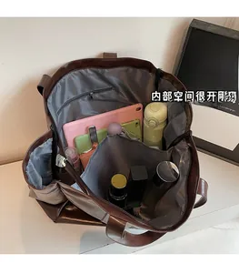 Close-up of the spacious interior of the brown leather tote bag filled with daily items