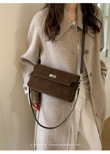 Detail of suede shoulder bag with silver metal turn-lock and vintage brown finish