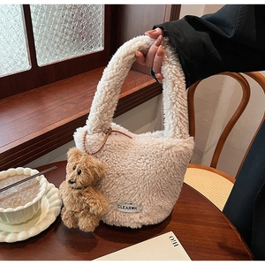 Détail du sac à main en peluche crème avec un accessoire de charme d'ours brun mignon