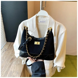 Detail of black quilted crossbody bag with golden clasp and leather woven chain strap