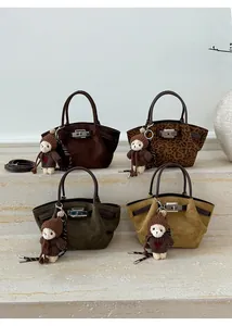 Detail view of four vintage suede handbags with metal buckles and cute bear charms