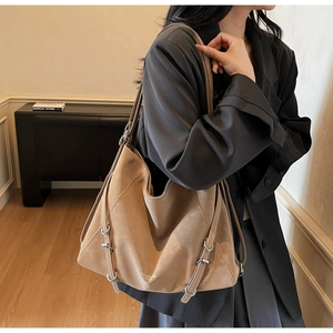 Detail of khaki leather tote bag with decorative metal buckle and matte texture