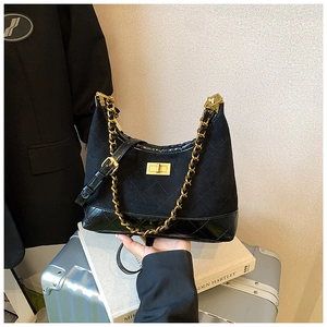 Detailed view of the diamond quilted texture and golden twist lock on the black hobo bag