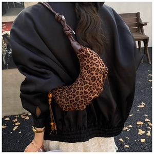 Detail of leopard print hobo bag with brown knotted strap and beaded tassel pendant