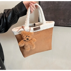 Close-up of fuzzy white faux fur and caramel suede tote bag with a cute bear charm