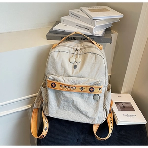 Detail of light grey nylon backpack with stylish wide patterned straps and durable zippers