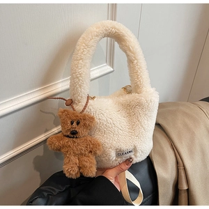 Détail du sac seau blanc en laine d'agneau peluche avec breloque ours et sangle