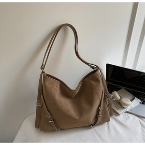 Brown vintage tote bag with silver metal rings styled with lifestyle props for daily use